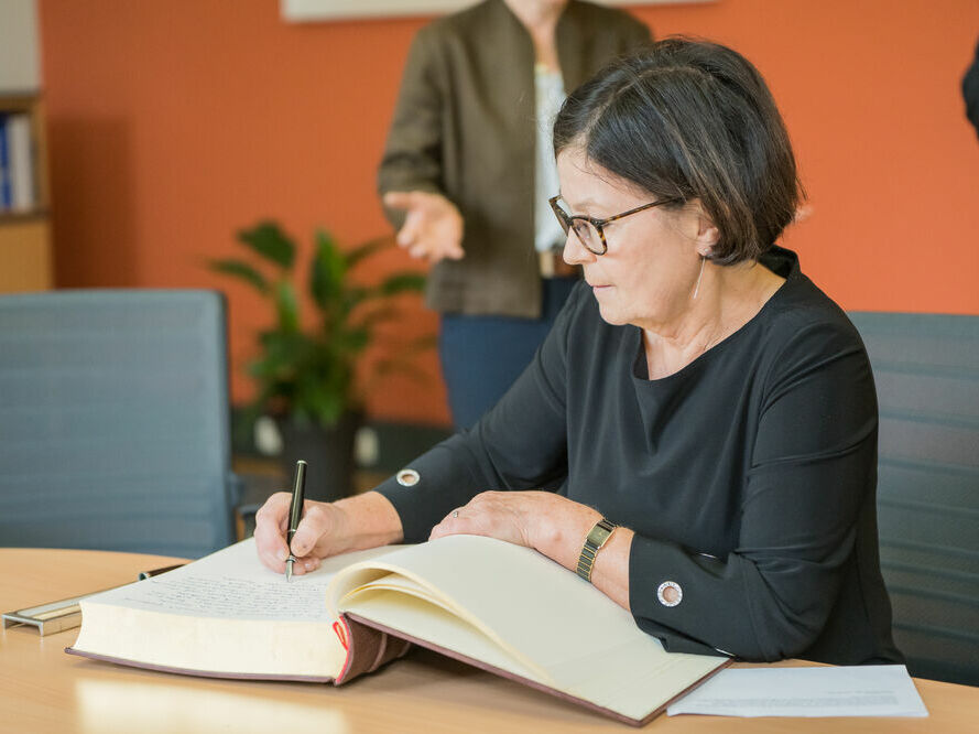 Honorary doctor Prof. Dr. Kaisa Häkkinen making her entry into the official guest book, © Laura Schirrmeister, 2021 