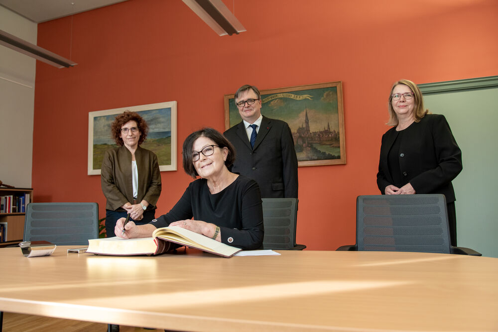 Prof. Dr. Kaisa Häkkinen signs the University's Book of Honour, ©Laura Schirrmeister, 2021