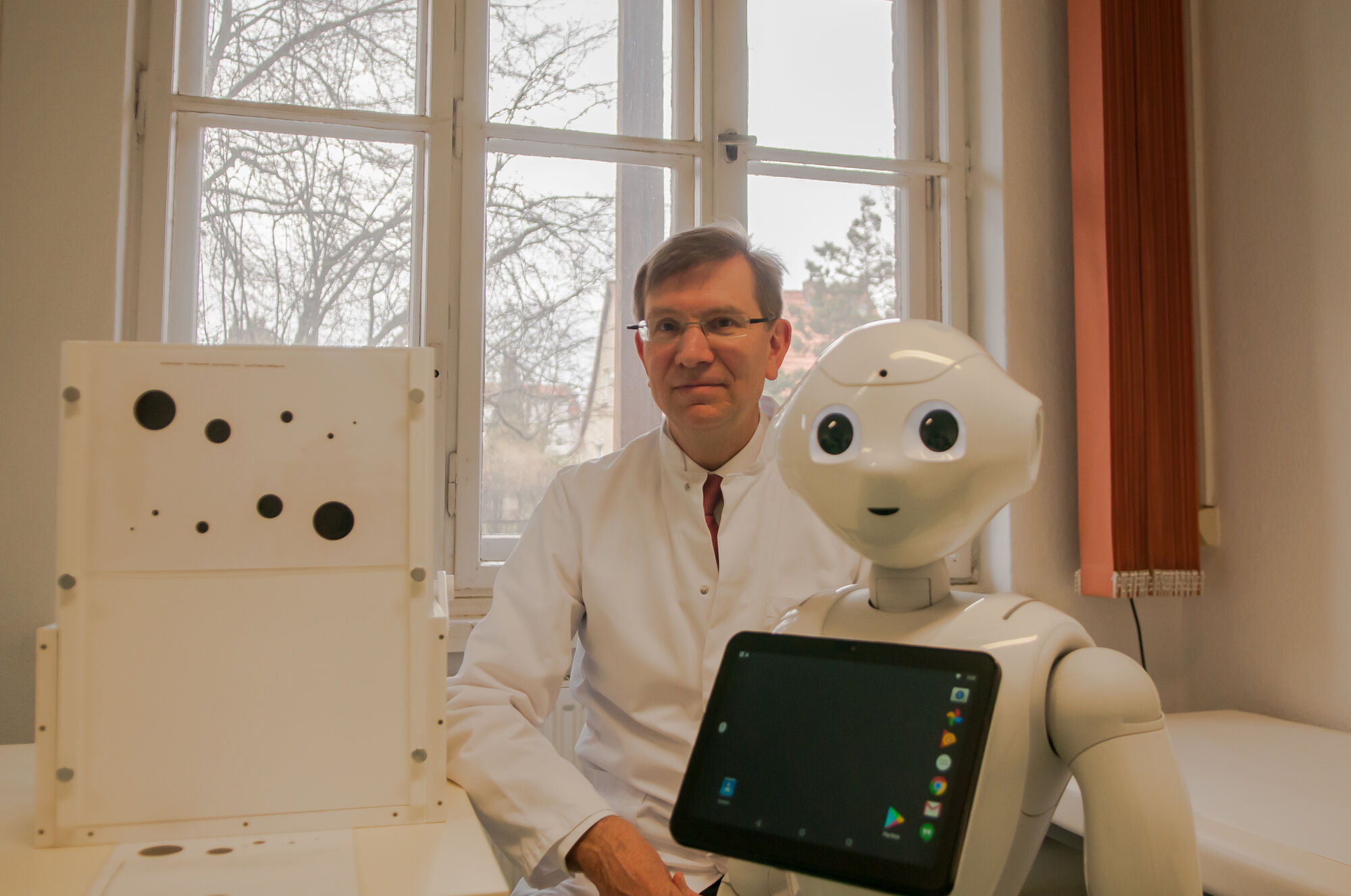Prof. Dr. Thomas Platz and a humanoid robot, © Laura Schirrmeister, 2021