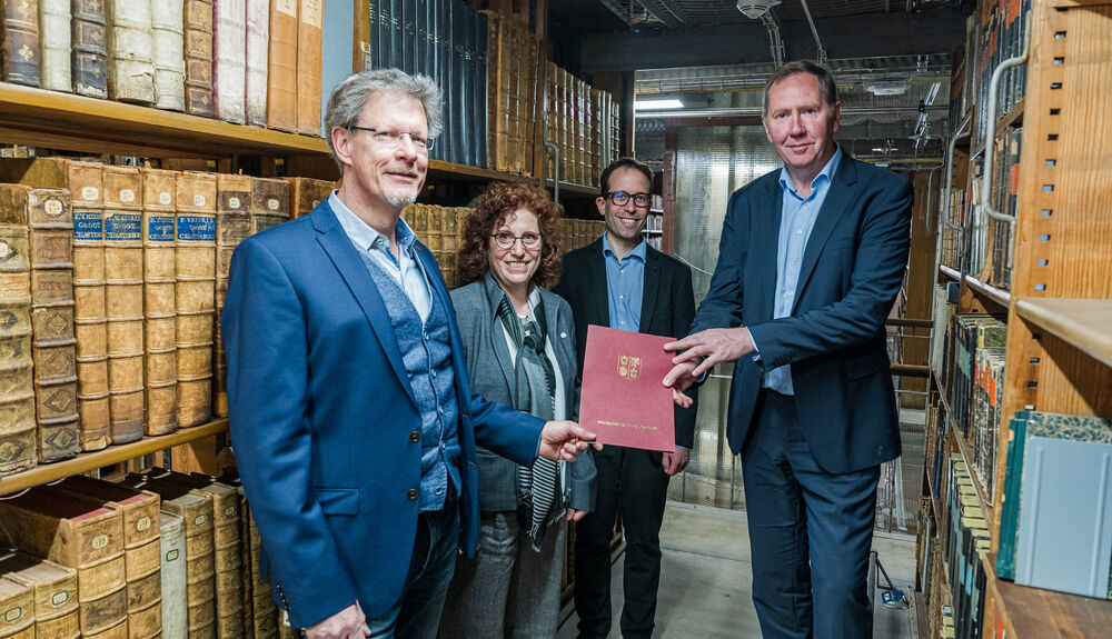 Heiko Miraß übergibt den Förderbescheid im Magazin der Alten Universitätsbibliothek , v.l.n.r. Ivo Asmus,  Prof. Dr. Katharina Riedel, Christian Winterhalter, Heiko Miraß,