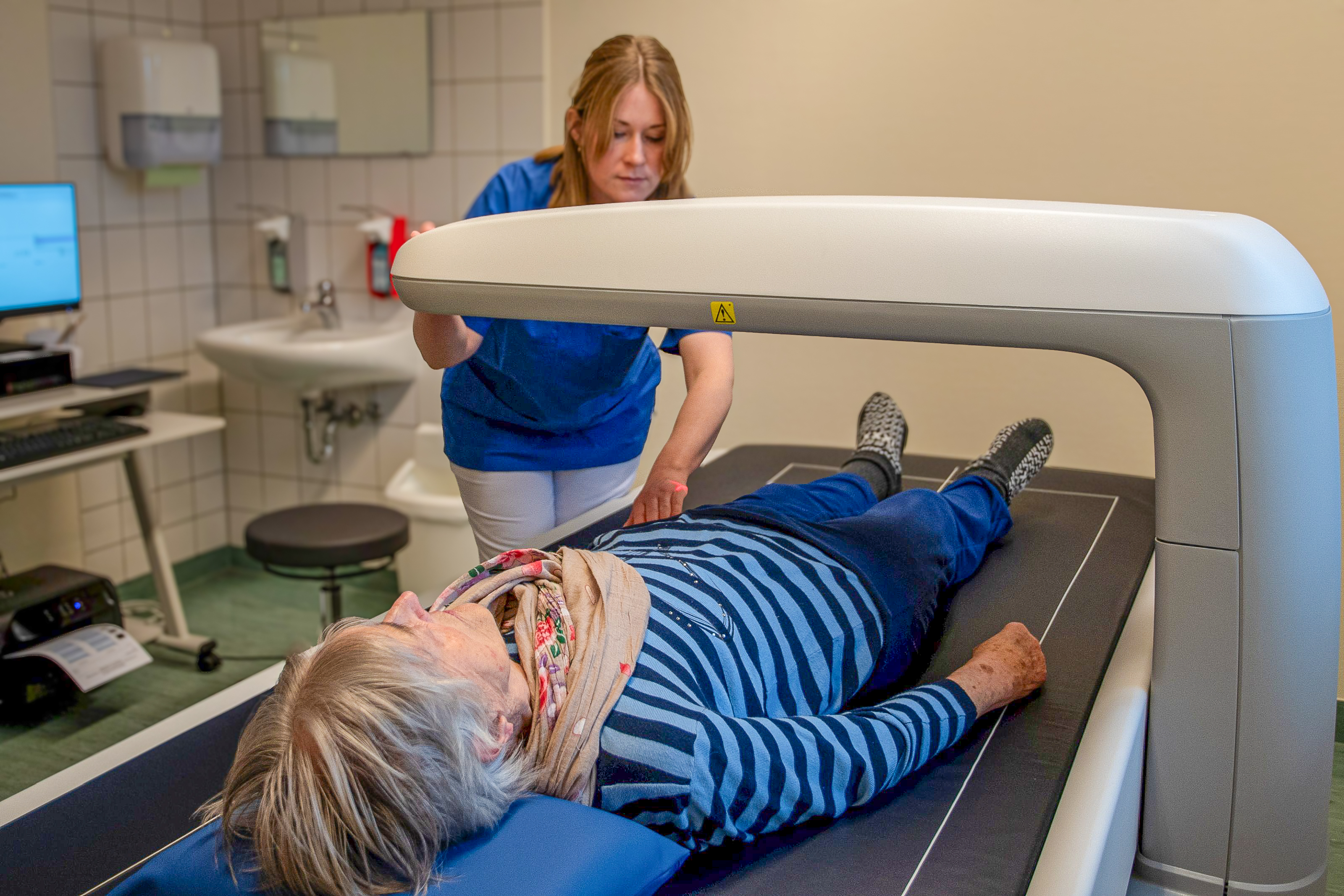 Die Leitende Studynurse misst bei einer Testprobandin mittels eines innovativen digitalen Röntgenverfahrens (DXA) die Knochendichte. (Studie MV-Fit)