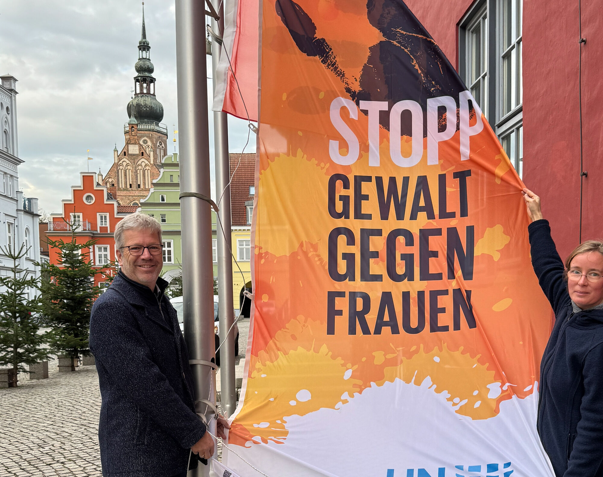 Der Oberbürgermeister der Stadt hisst die die UN Woman-Fahne 2024 vor dem Rathaus.