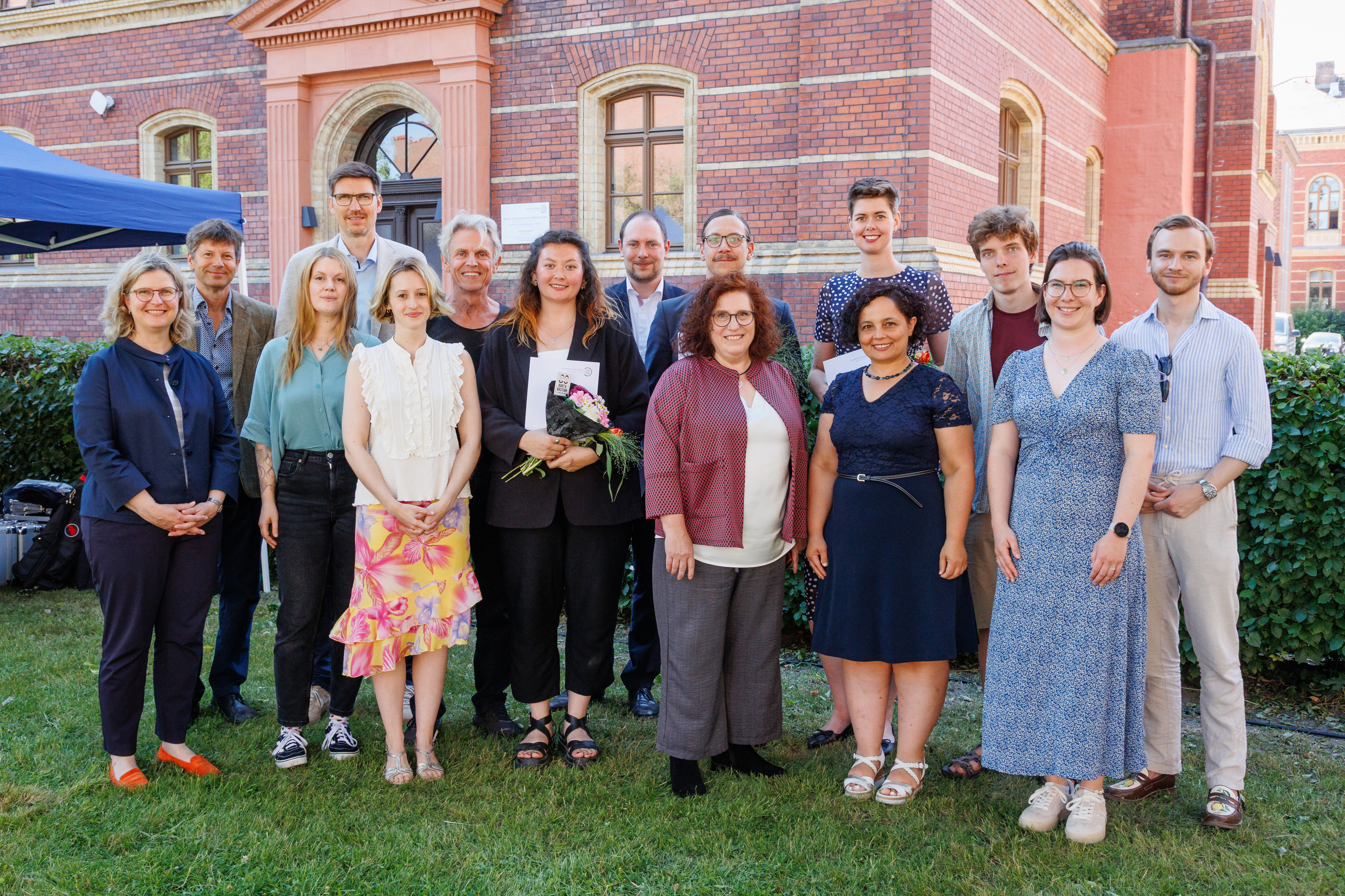 The award winners can be seen in the centre of the photo, from left to right: Jens Rasmussen, Aliya Mironova, Lucas Hennicke, Tobias Gnüchtel, and Klara Greffin at the award ceremony during Dies academicus Several people standing between trees and on grass, posing for a photo.