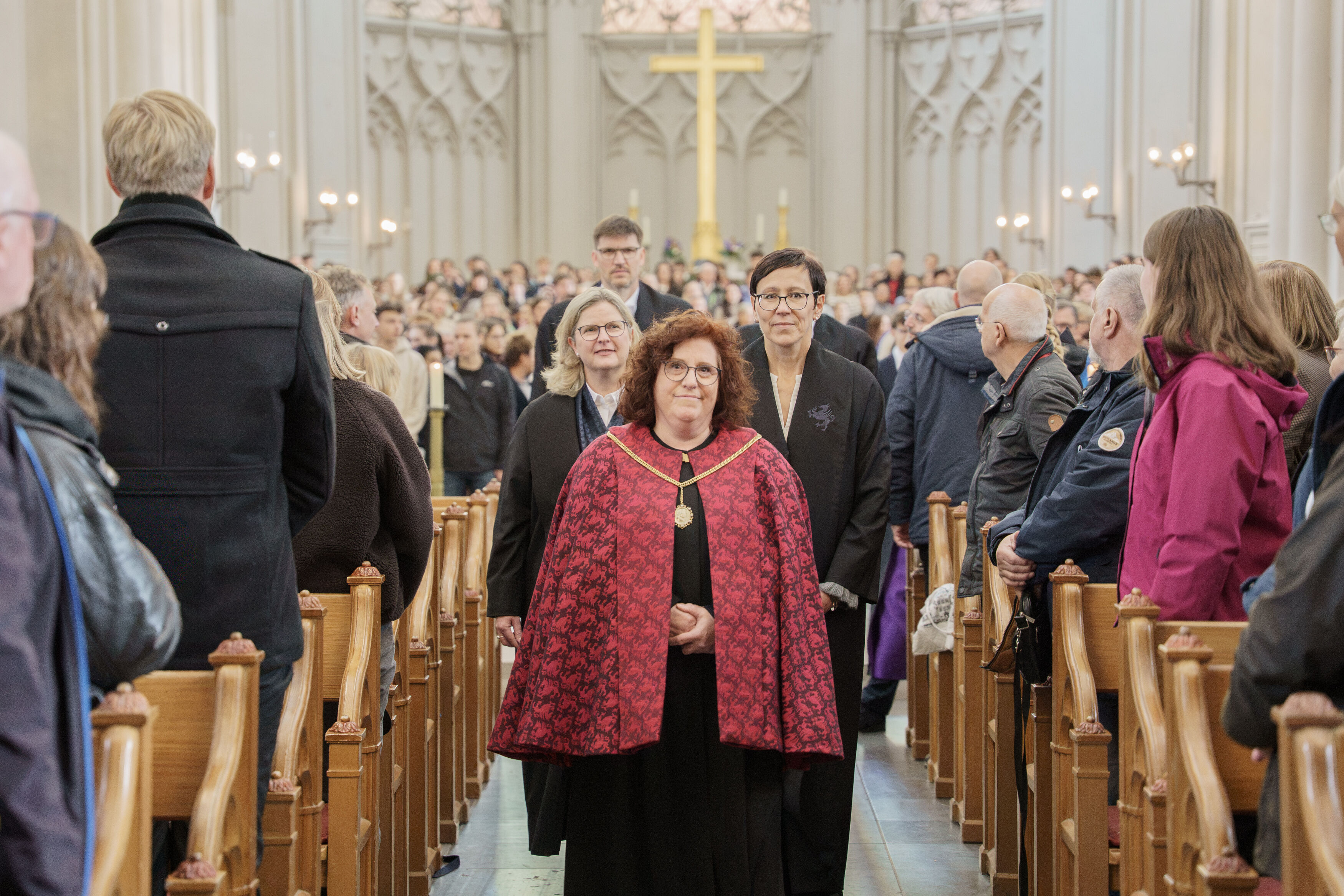 Einzug des Rektorats bei der Feierlichen Immatrikulation 2026 Menschen laufen in einer alten Kirche durch den Gang.