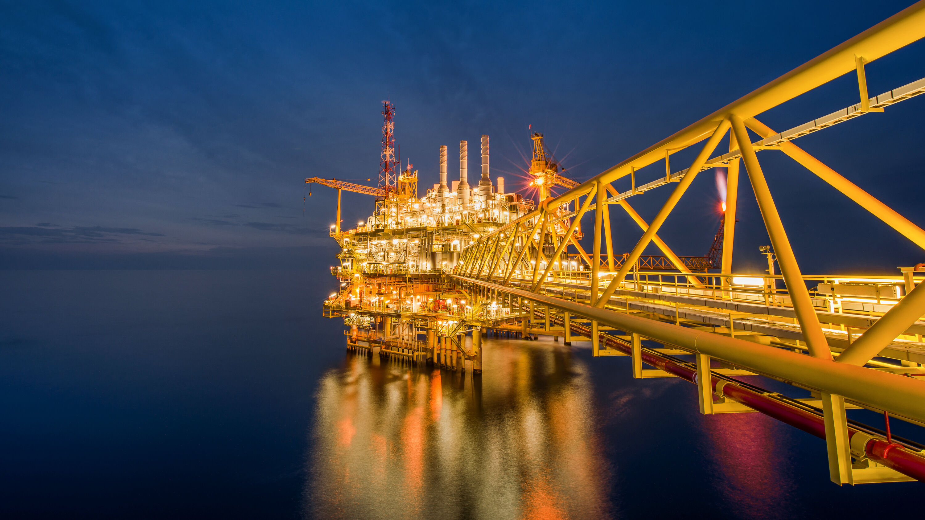 Industrial Offshore oil and gas rig platform at night in the gulf of Thailand. Eine industrielle Offshore-Öl- und Gasbohrplattform bei Nacht im Golf von Thailand.