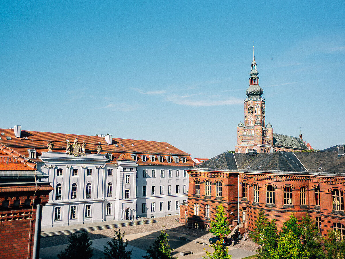 Bild vom Campus Rubenowstraße auf den Greifswalder Dom bei Sonnenschein.
