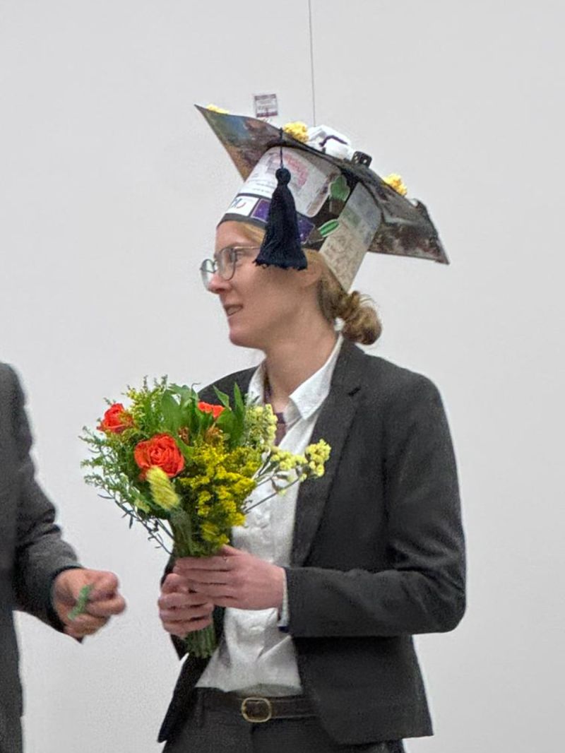 Larissa Busch nach ihrer Verteidigung mit Blumenstrauß und Absolventenhut