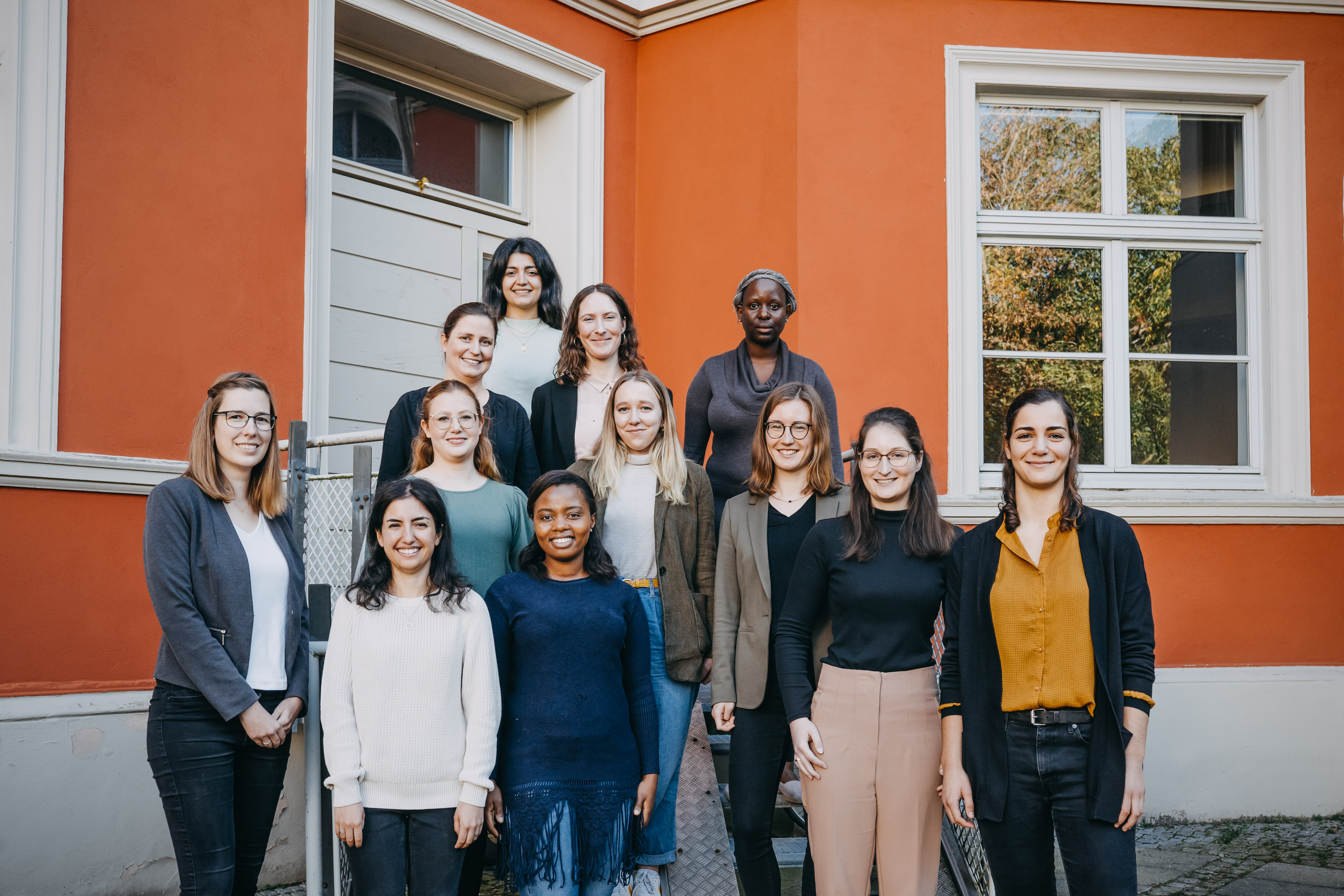 zwölf Frauen stehen auf einer Treppe verteilt