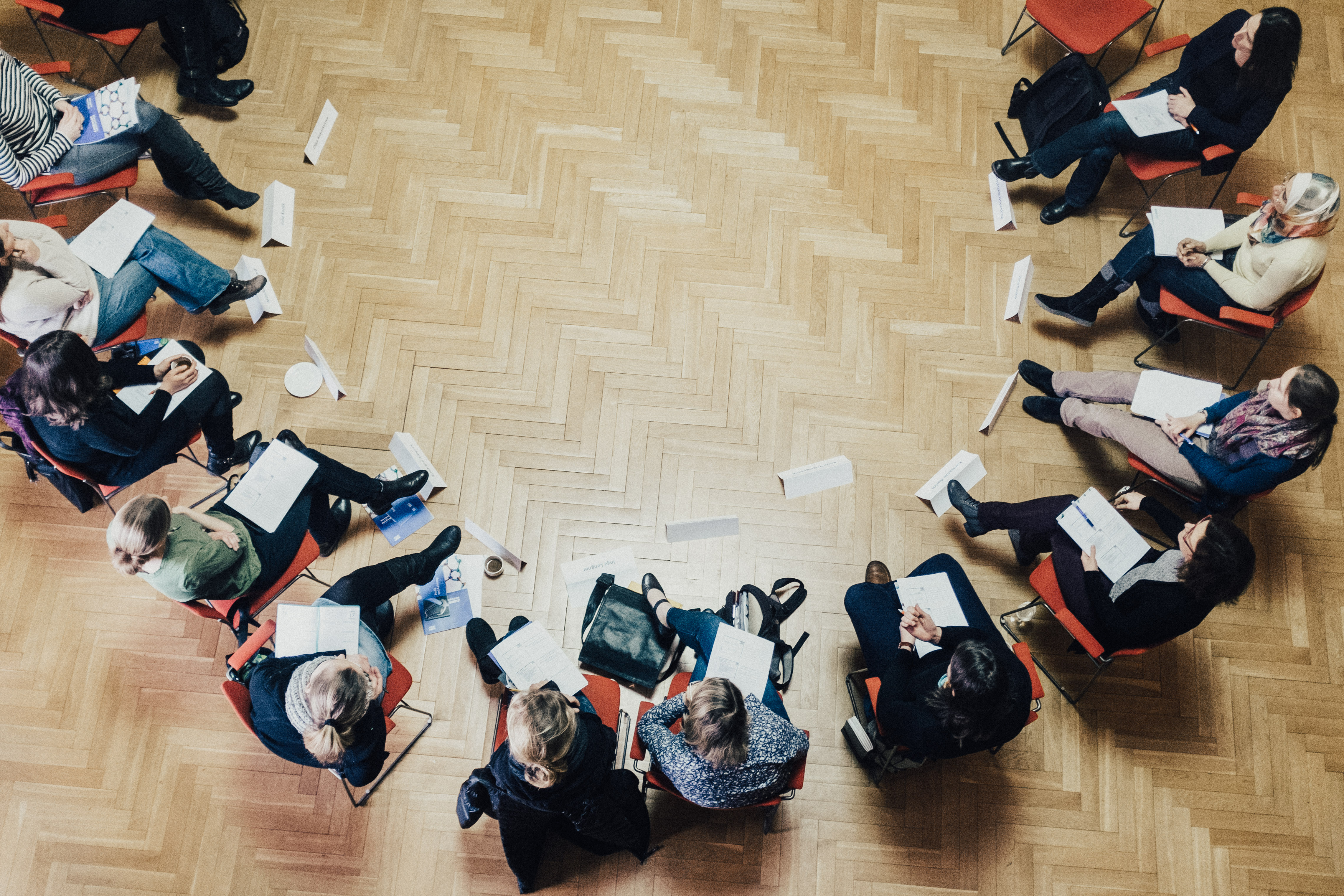 Mentoring Gruppe in Runde sitzend von oben fotografiert