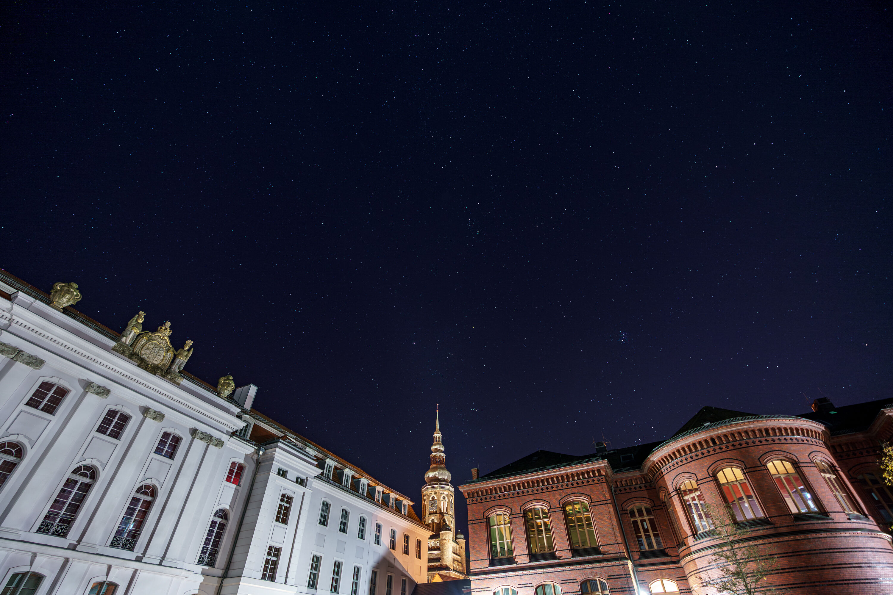Historic Campus with a starry sky The image shows the Historic Campus with a starry sky. The Main Building is on the left and the Altes Audimax on the right. The St. Nikolai cathedral can be seen in the centre