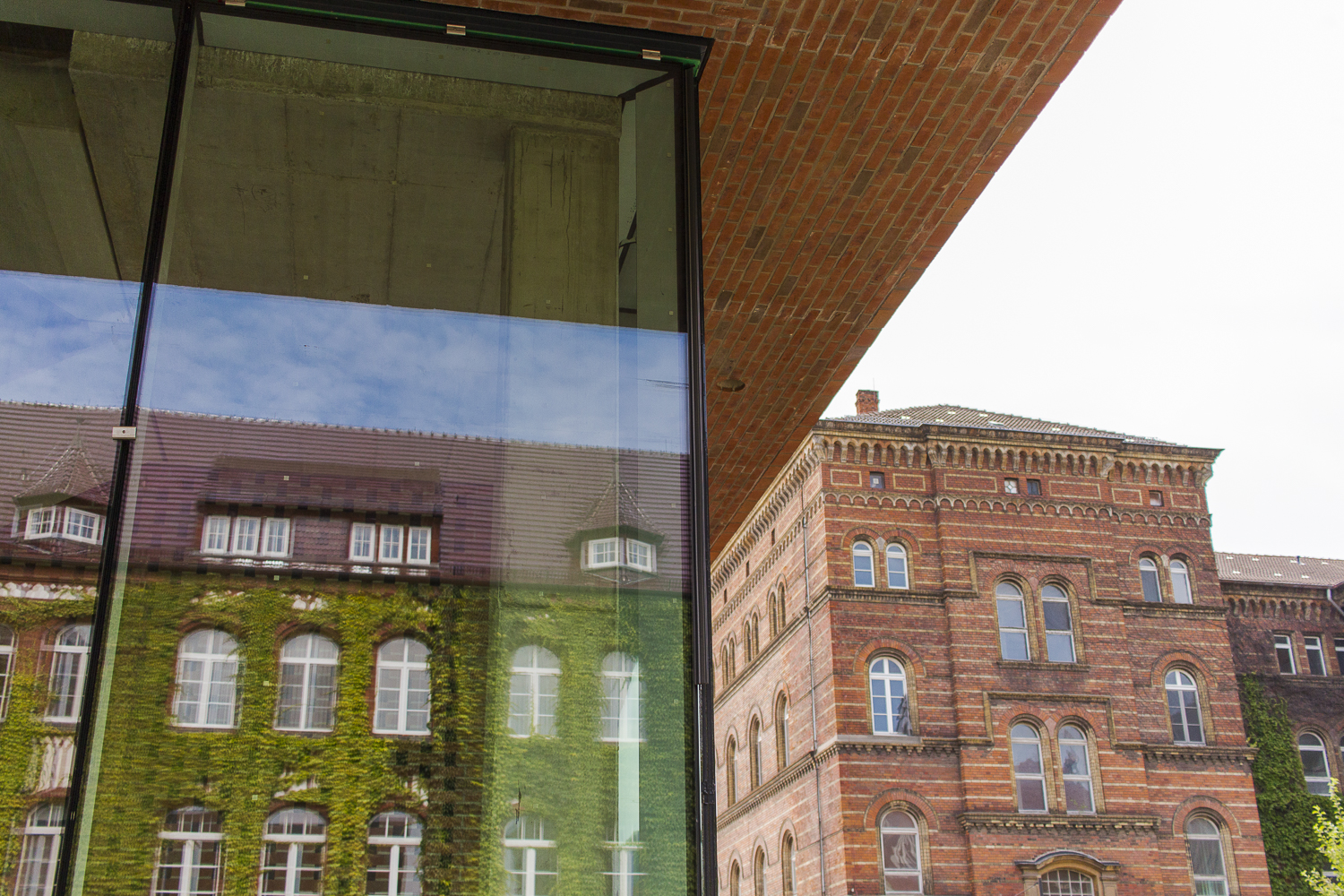 Die alten Gebäude spiegeln sich in der Fassade des Hörsaalgebäudes
