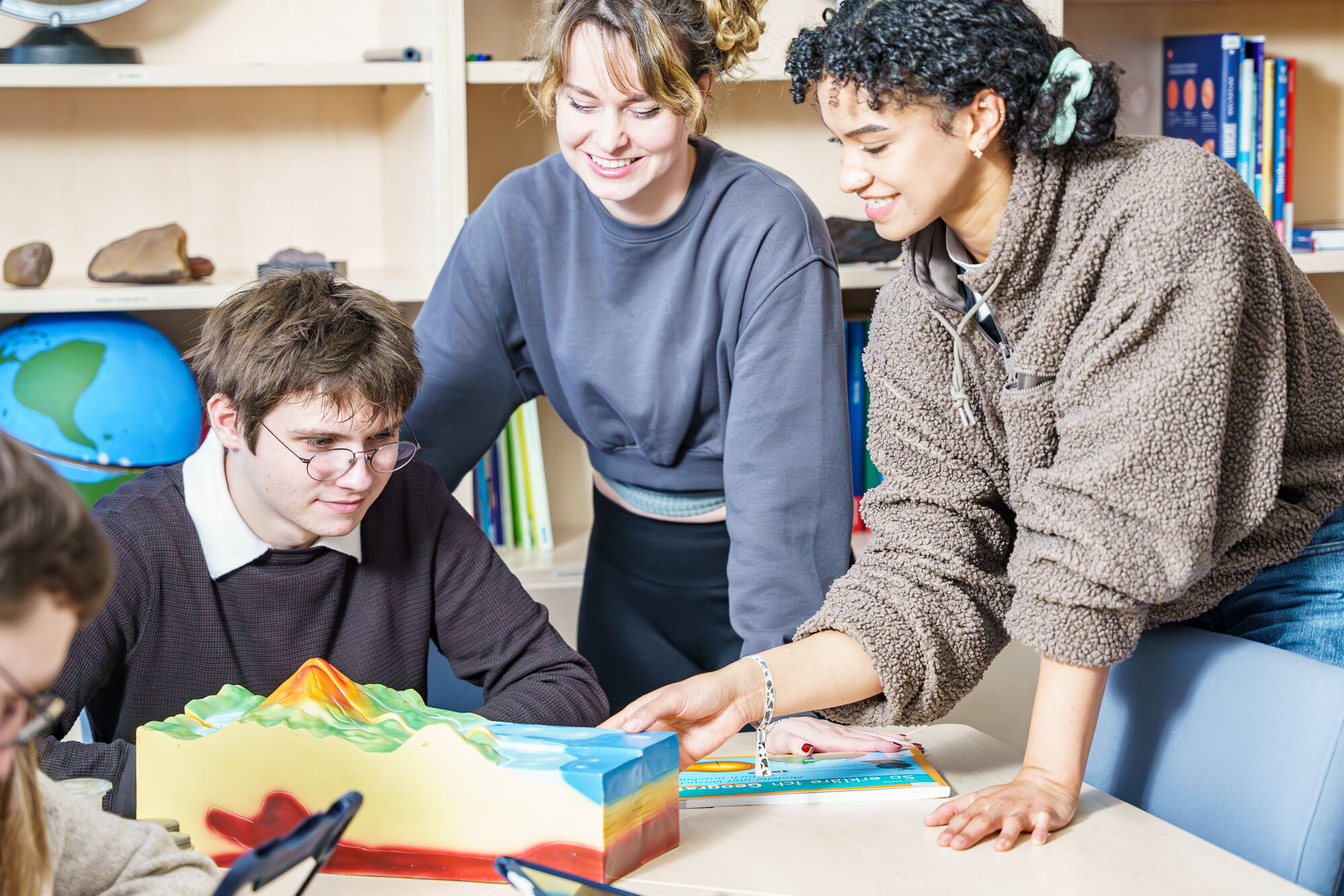 Studierende schauen sich im Seminar verschiedene Unterrichtsmaterialien an.