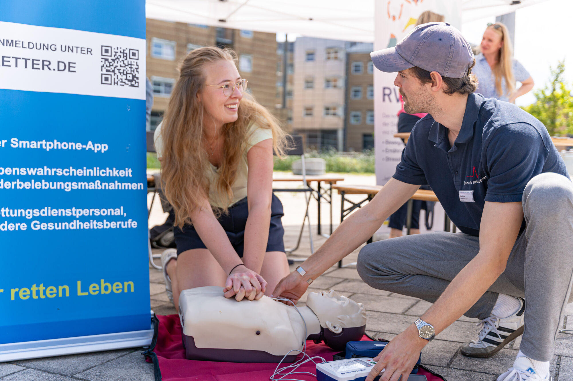 Gesundheitstag 2024 Ein Medizinstudent erklärt an einem Übungskörper, wie eine Herz-Druck-Massage durchgeführt wird.