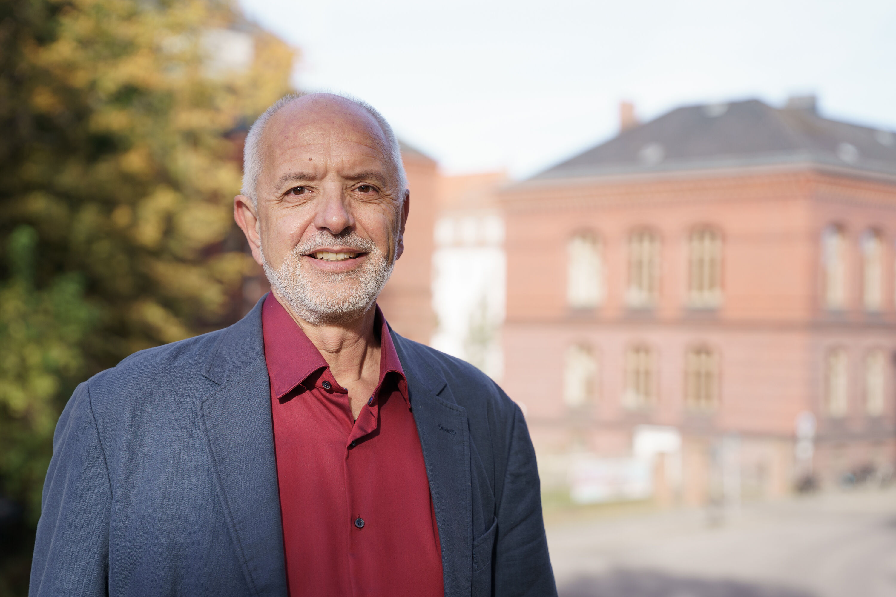 Porträt Prof. Dr. Jan Körnert Porträt Prof. Dr. Jan Körnert. Im Hintergrund ist die Universität zu sehen.