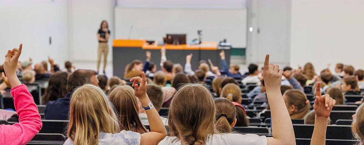 Kinder- und JugendUNI In einem Hörsaal melden sich Kinder