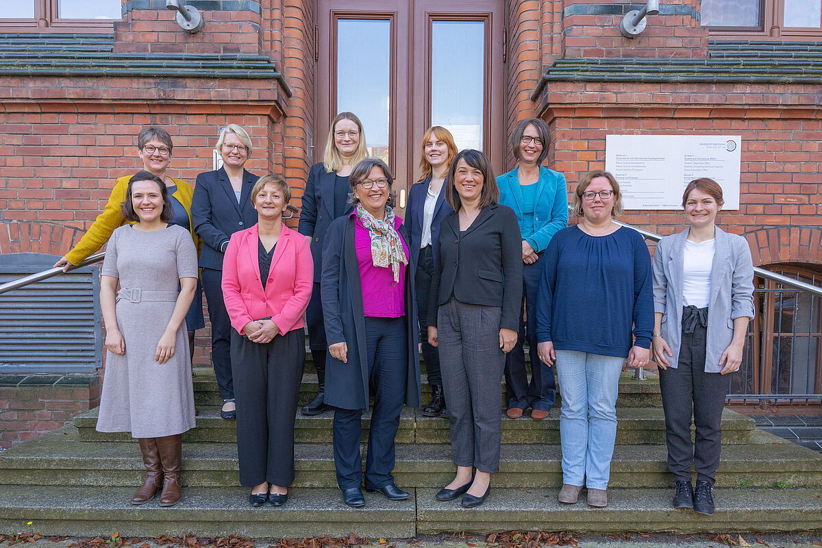 Gruppenfoto der Teilnehmenden des Besuchs der Ministerin vor einem Universitätsgebäude