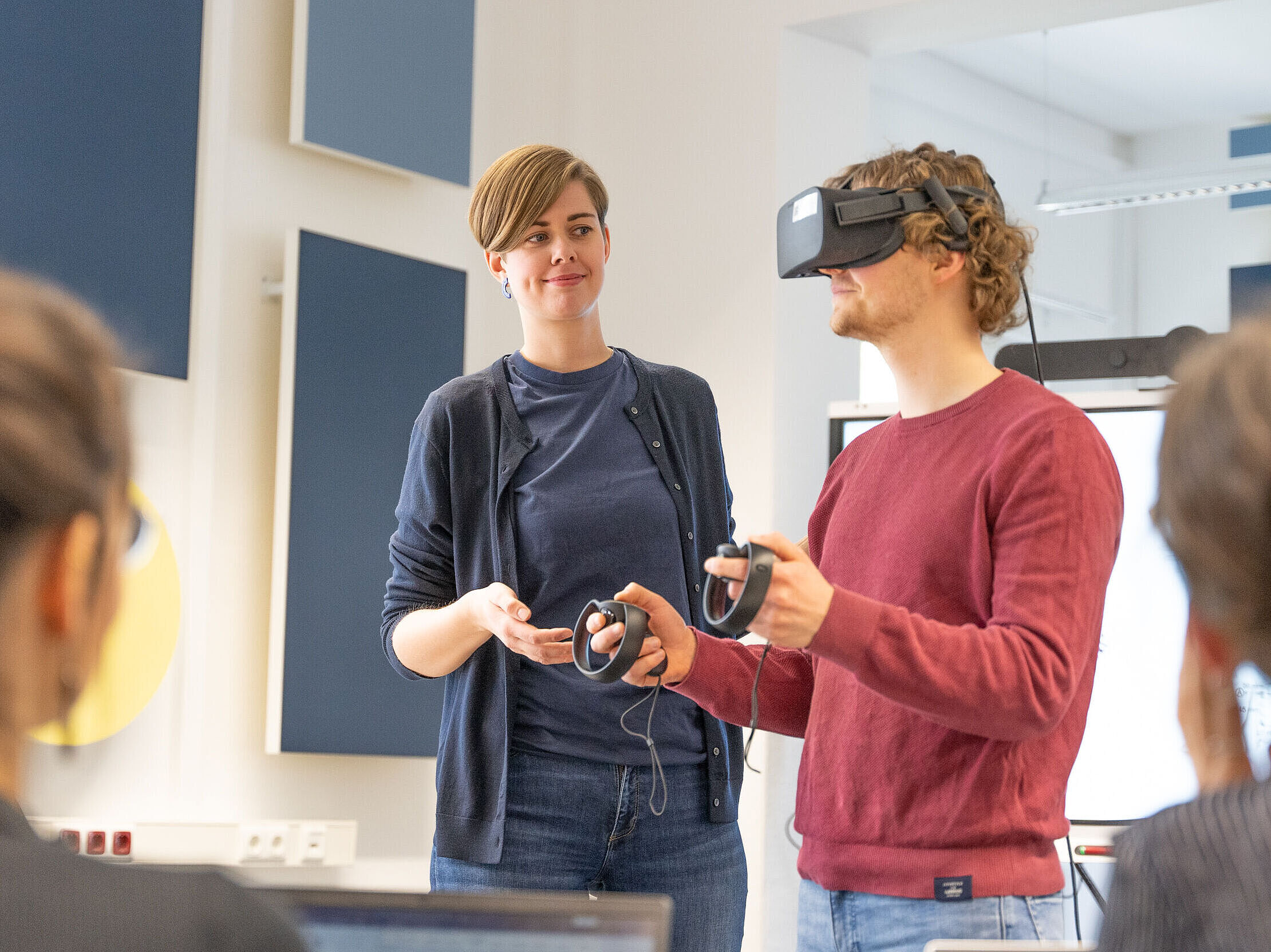 In einem Seminar wird von einer Personengruppe eine VR-Brille getestet.
