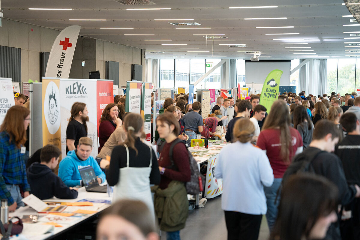 Zwischen unterschiedlichen Ständen verschiedener Initiativen informieren sich Studierende über das Angebot.