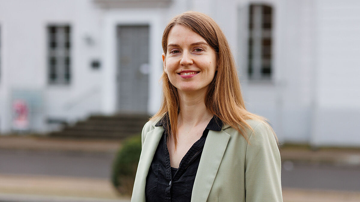 Auf dem Foto ist Fiona Schmidt vor dem Unihauptgebäude zu sehen.