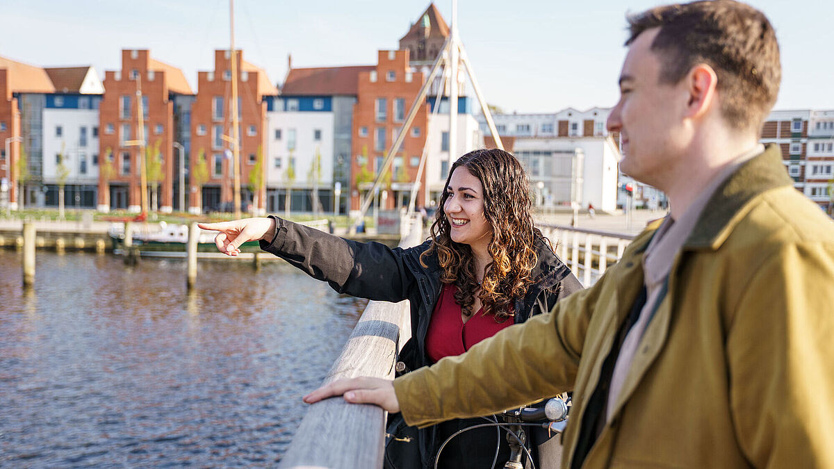 Studierende stehen auf einer Brücke am Museumshafen.