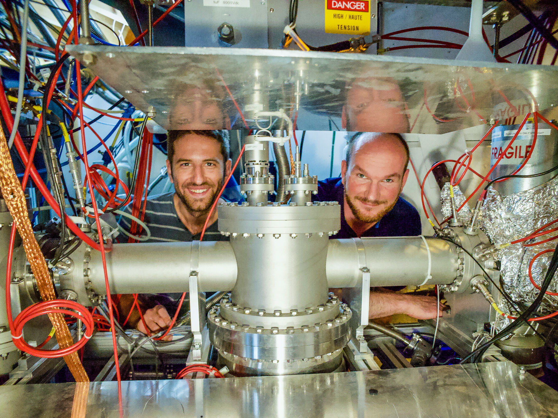 Dinko Atanasov und Frank Wienholtz (rechts) hinter der MR-ToF MS-Komponente der ISOLTRAP-Apparatur in der ISOLDE-Experimentierhalle am CERN – ©Jonas-Karthein