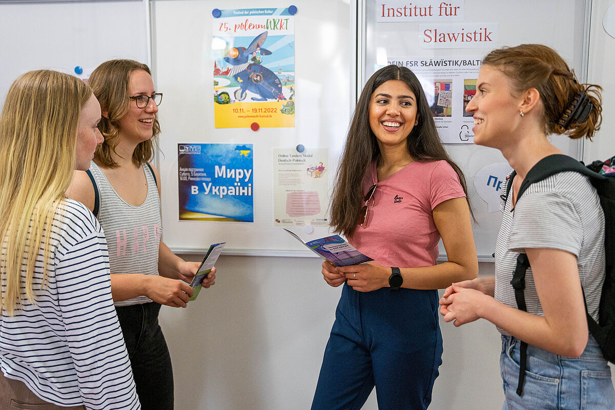 Auf dem Foto sieht man eine Gruppe junger Mensche, welche sich über ihr Studium der Slawistik unterhalten.