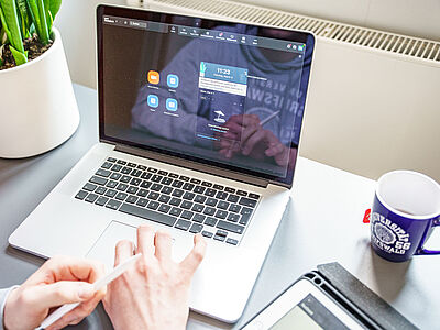 Eine Person sitzt vor einem geöffneten Laptop in einem Zoom-Meeting.