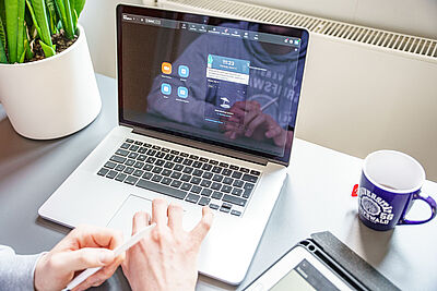 Eine Person sitzt vor einem geöffneten Laptop in einem Zoom-Meeting.