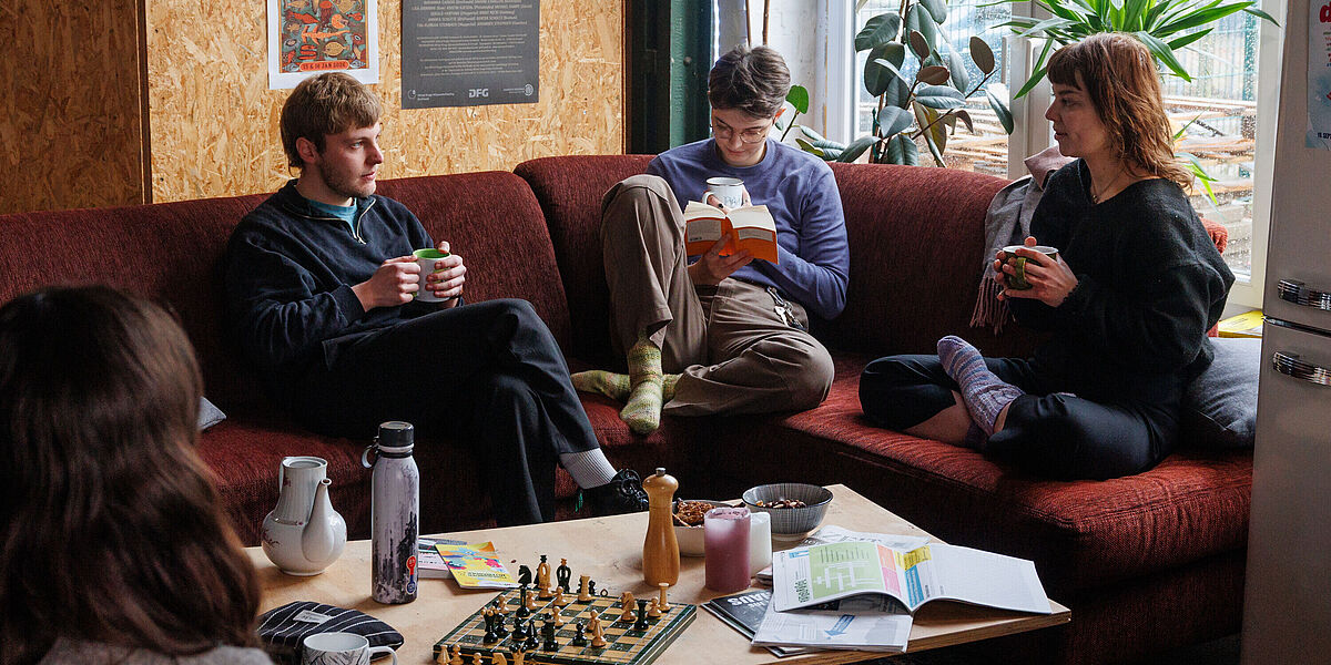 Studierende unterhalten sich in einem Café über ihr Philosophie-Studium.