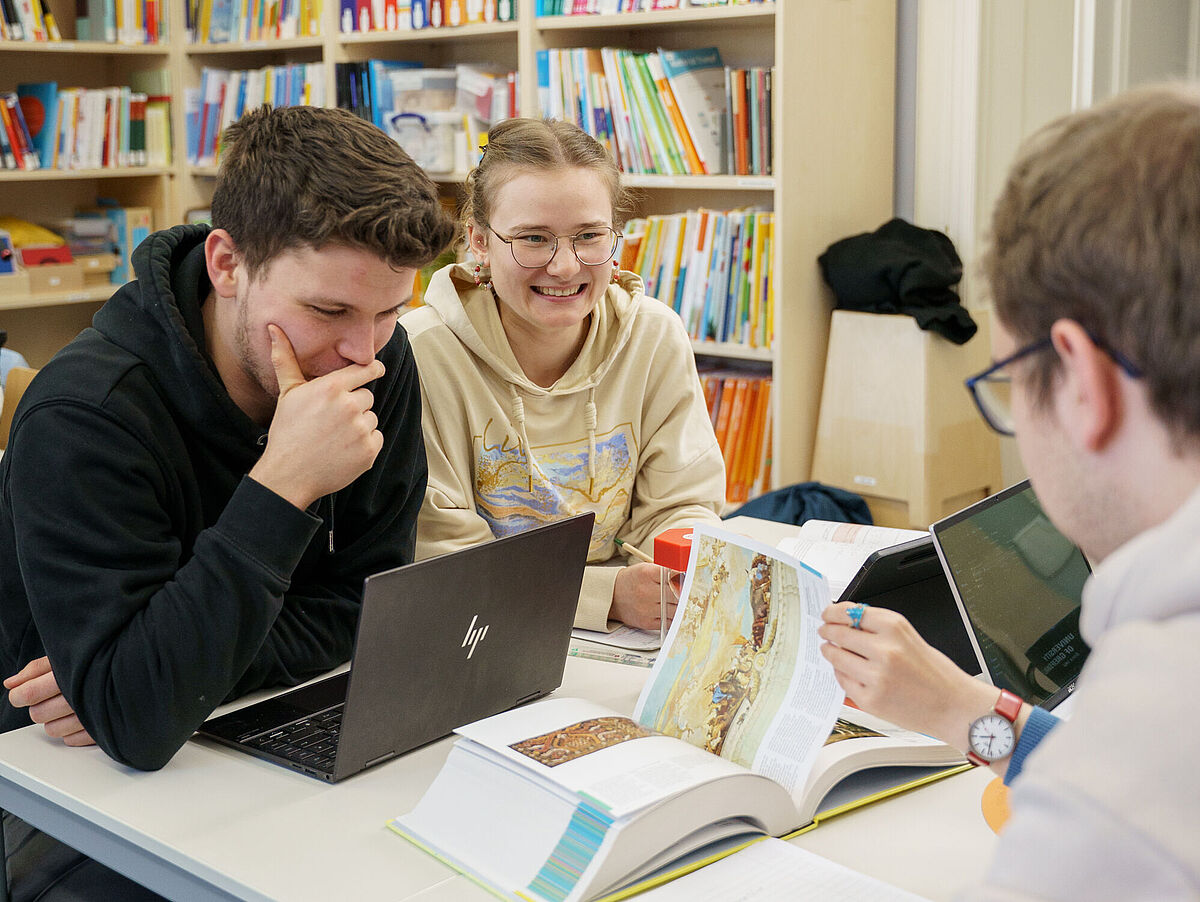 Studierende lernen zusammen an einem Tisch. 