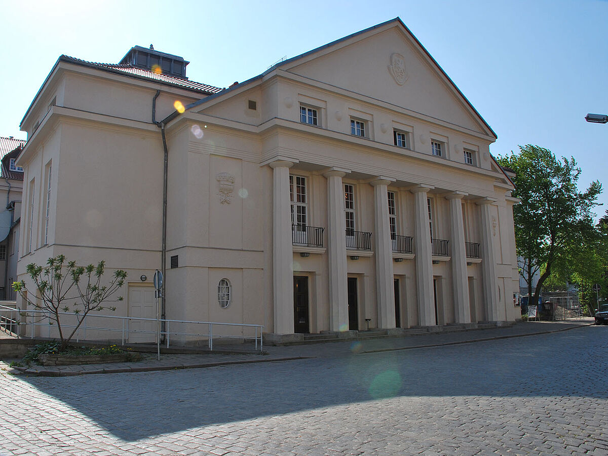 Das Theater Vorpommern und sein säulengetragener Eingang von außen.