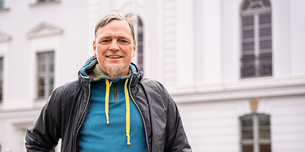 Porträt Prof. Dr. Gerald Jurasinski vor dem Hauptgebäude der Uni Greifswald