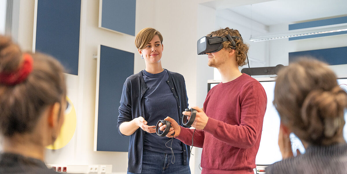 In einem Seminar wird von einer Personengruppe eine VR-Brille getestet.