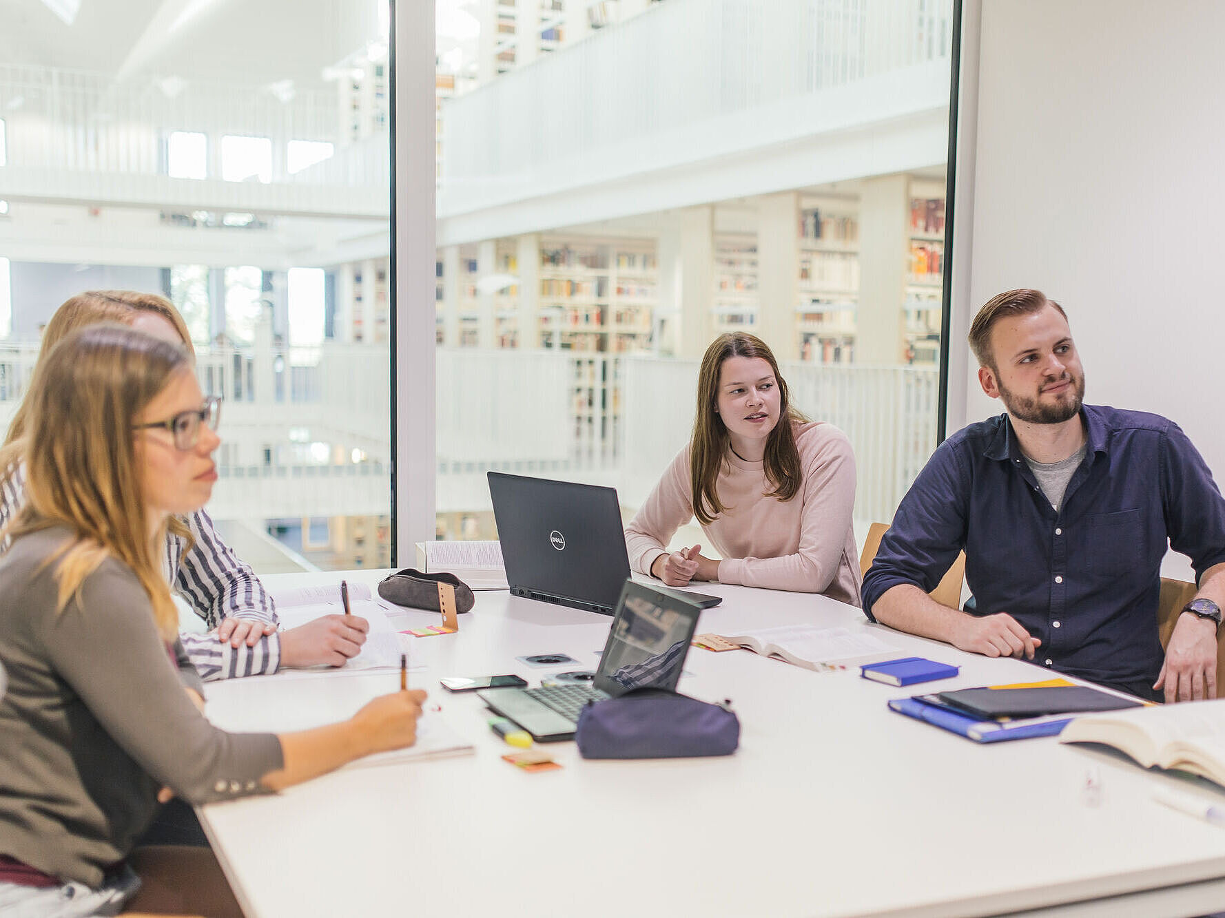Symbolbild Lernsituation Lernsituation in der Bereichsbibliothek: Vier Personen sitzen in einem Gruppenraum an ihren Notebooks.