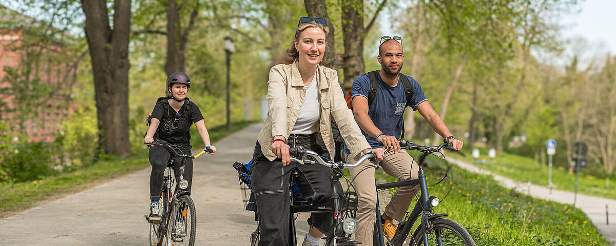 Zu sehen sind drei Fahrradfahrer*innen.