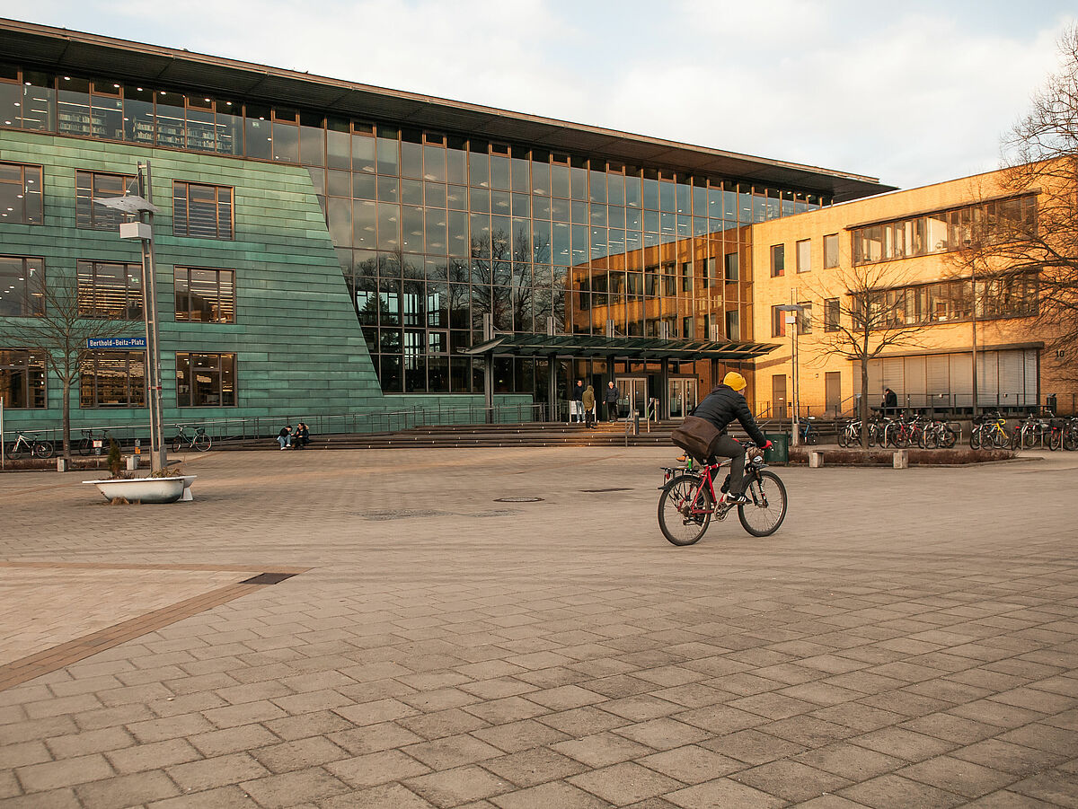 Ein Radfahrer fährt den Weg an der Zentralen Universitätsbibliothek entlang.