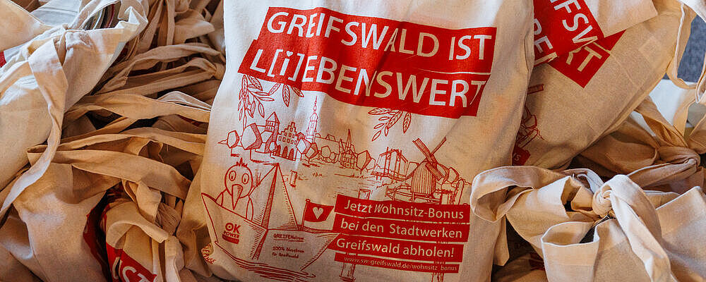 Mehrere gepackte Ersti-Beutel liegen auf einem Haufen. Auf ihnen gedruckt steht "Greifswald ist lebenswert"