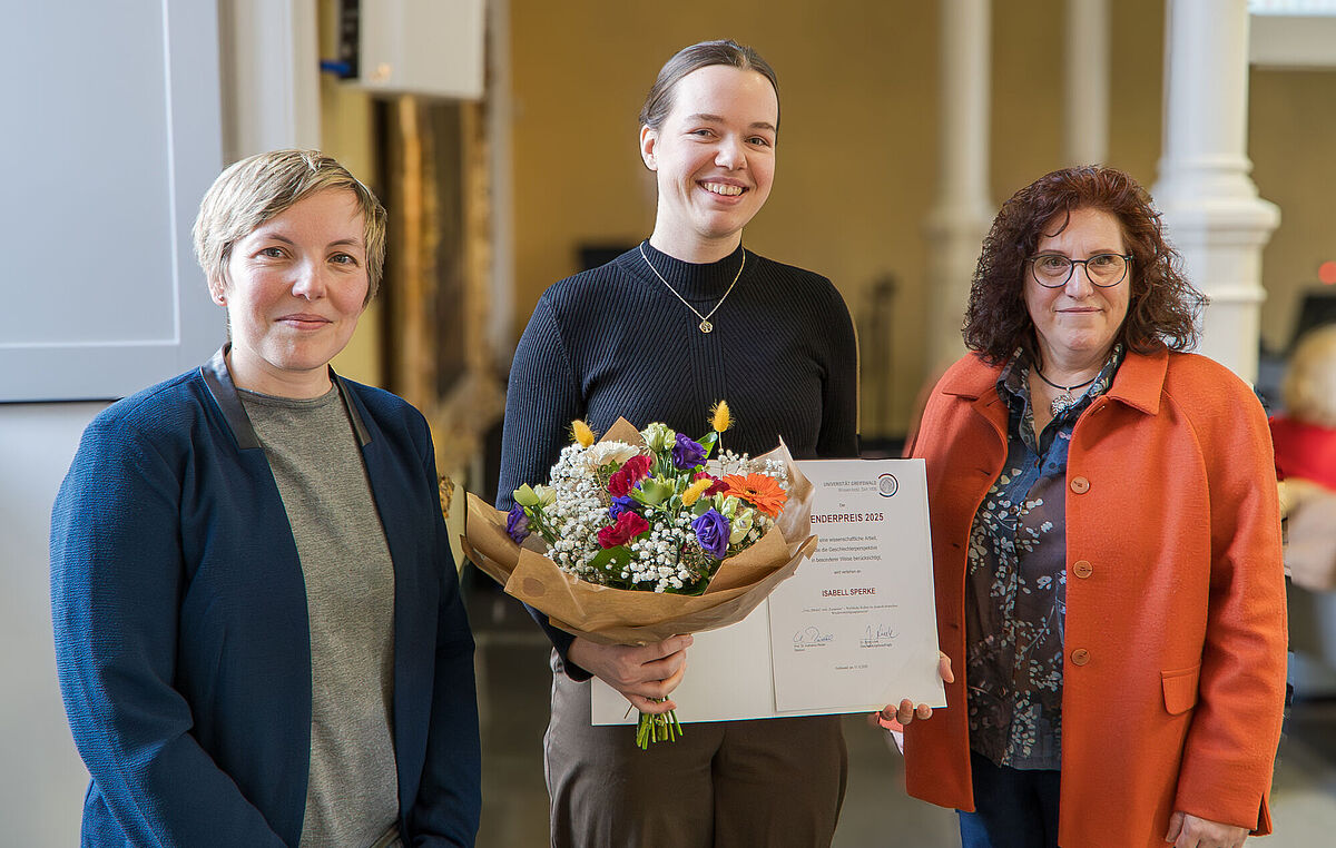 Auf dem Bild stehen drei Personen direkt vor der Kamera. (v.r.n.l.) Dr. Jenny Linek (Gleichstellungsbeauftragte),  Isabell Sperke (Preisträgerin), Prof. Dr. Katharina Riedel (Rektorin)