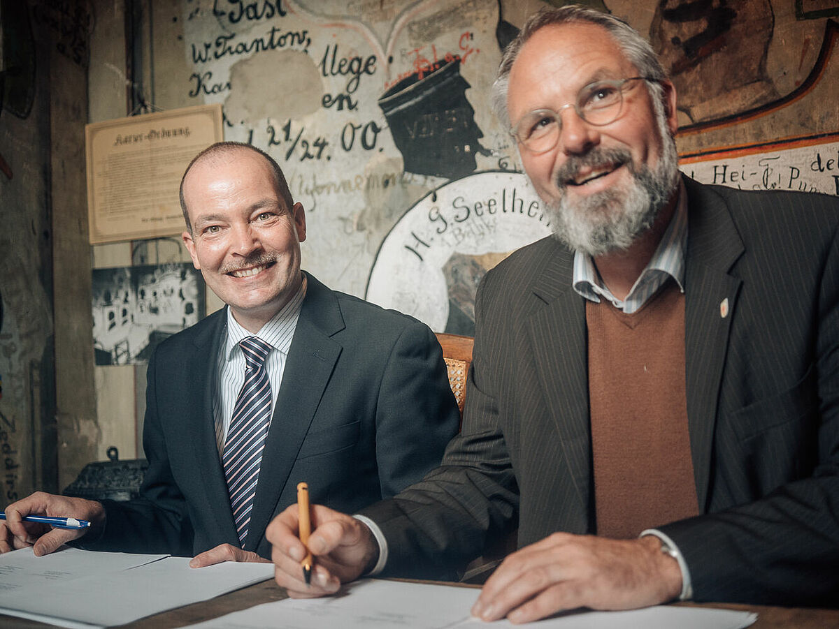 Der Kanzler der Universität Greifswald und der Geschäftsführer der Greifswald Marketing GmbH unterzeichnen den Kooperationsvertrag im Historischen Karzer - Foto: Magnus Schult