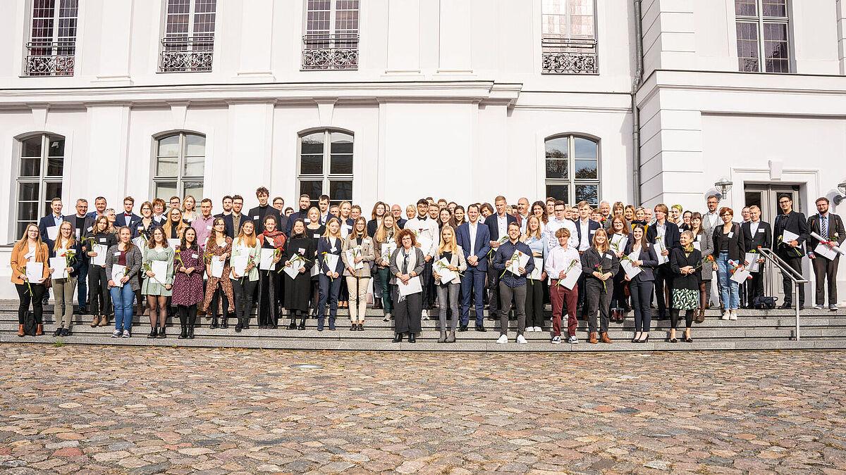 Gruppenbild von den Deutschlandstipendiat*innen und Fördernden 2022 vor dem Hauptgebäude der Universität.