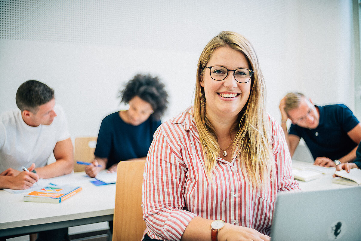 Eine Gruppe Studierender beim Lernen und Studieren in einem Seminarraum.