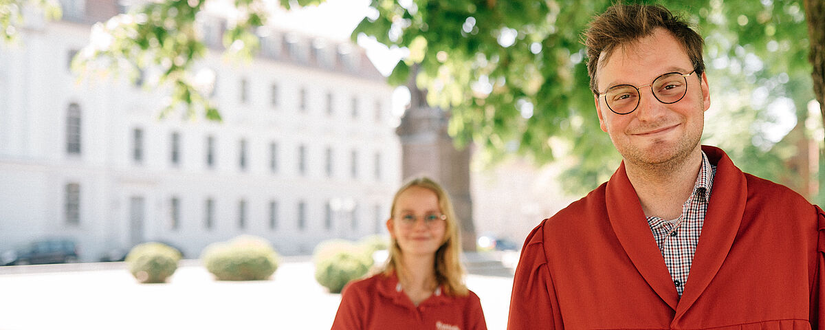 Public guided tours at the University Two student tour guides on the Rubenowplatz in front of the University Main Building