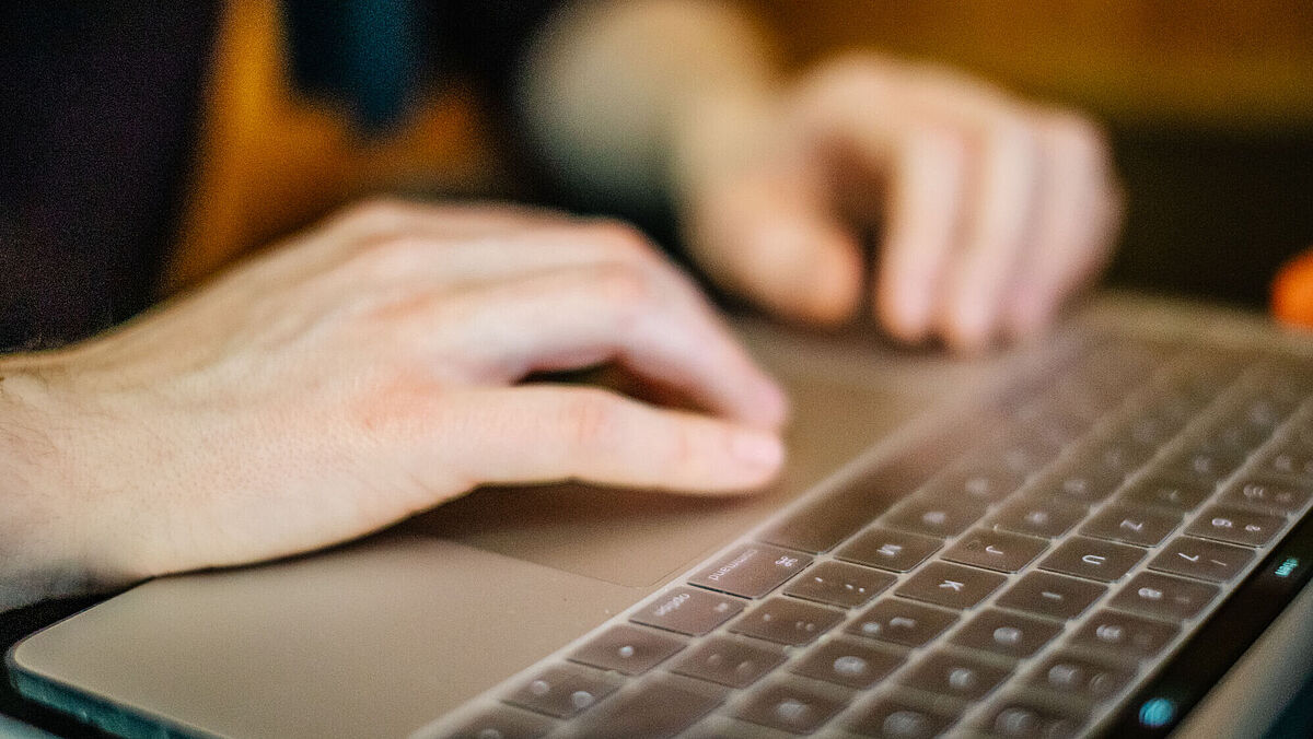 Zu sehen sind die beiden Hände einer Person, die auf einer Tastatur tippen.