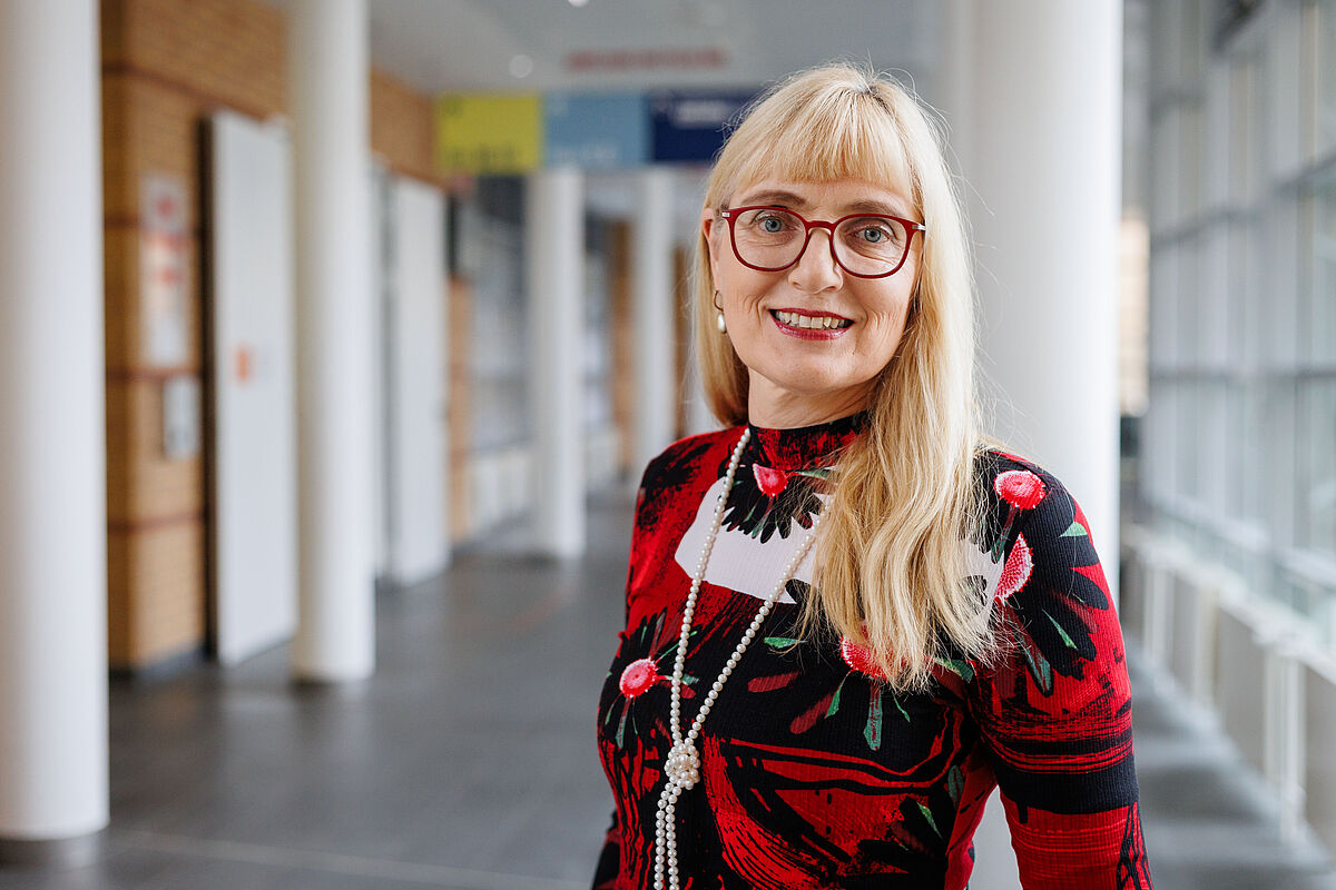 Dr. Gisela Hoffmann steht in einem Flur in der Universitätsmedizin Greifswald.