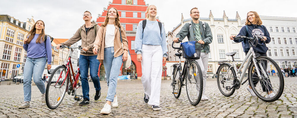 Studierende laufen über den historischen Marktplatz.