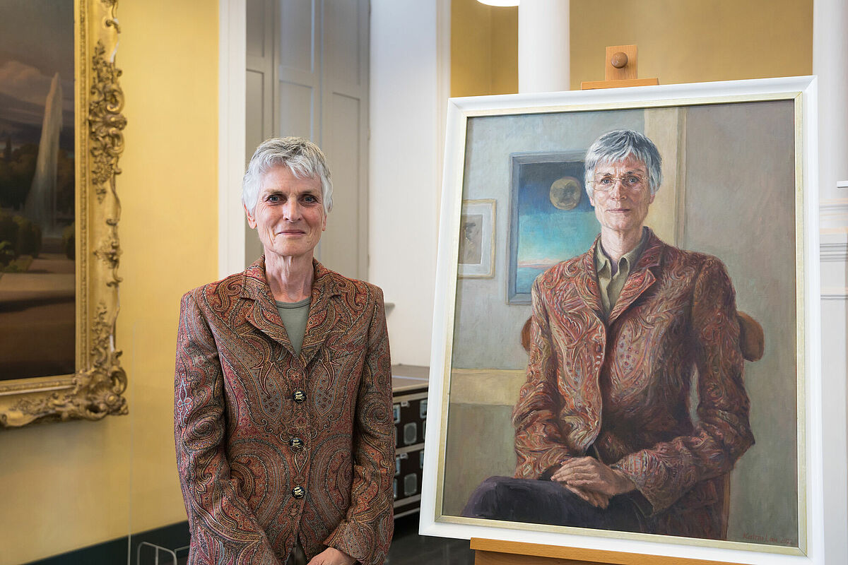 Prof. Dr. Johanna Weber vor ihrem Ölporträt, das die Künstlerin Katrin Lau schuf.